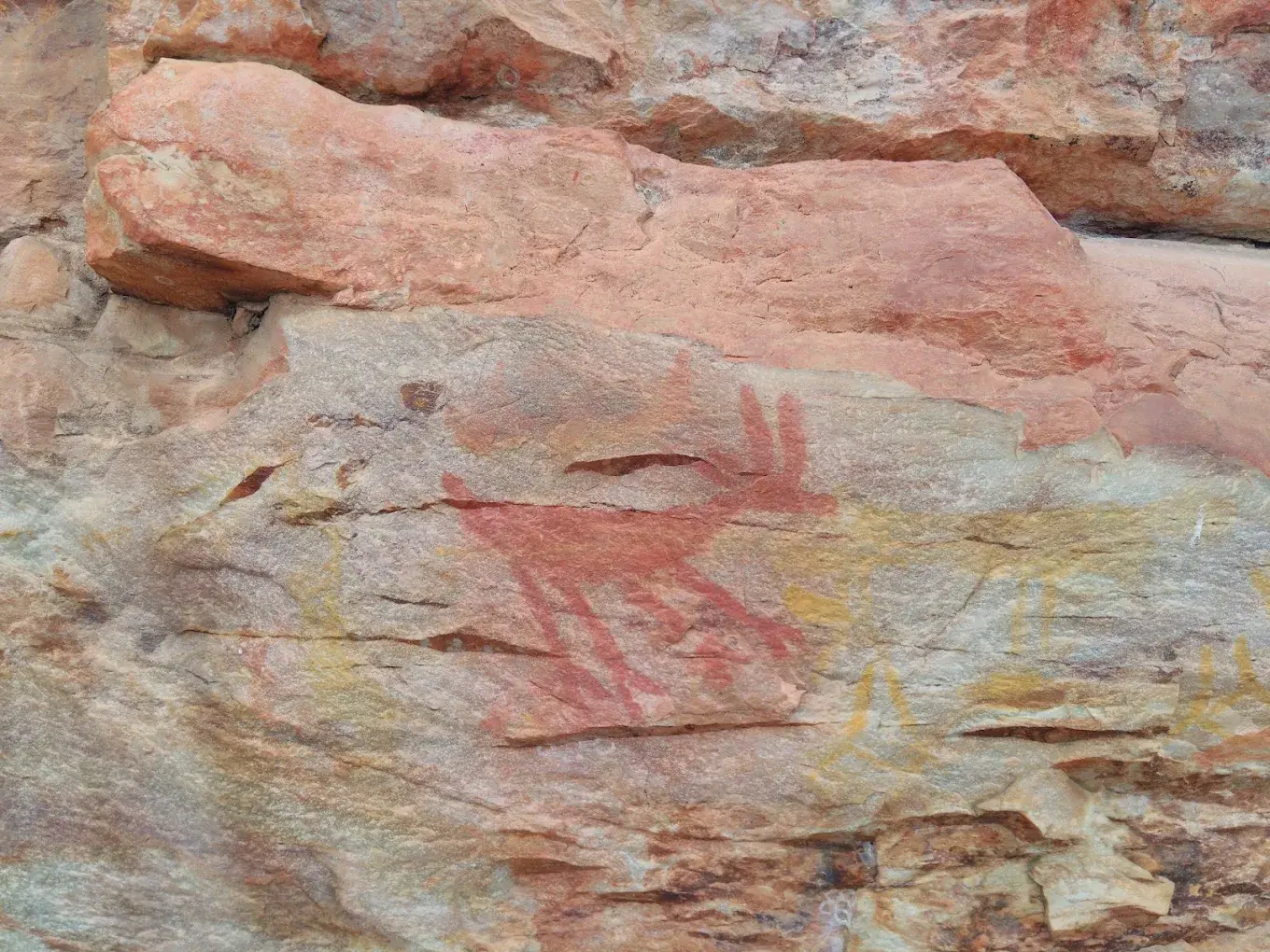 Paredão com o painel de pinturas rupestres em Lapinha da Serra, com figuras em pigmento ocre