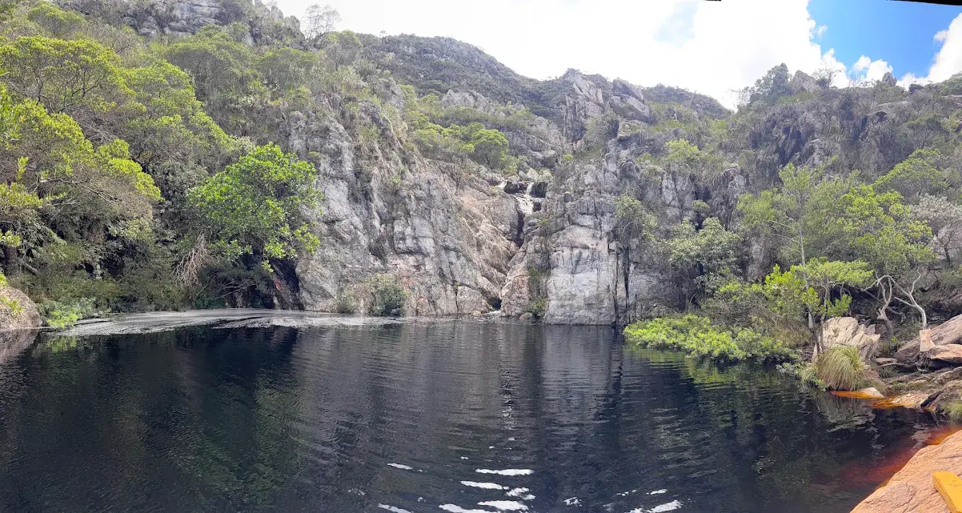 Poço profundo e escuro da Cachoeira do Boqueirão, encaixado entre paredões de pedra em Lapinha da Serra