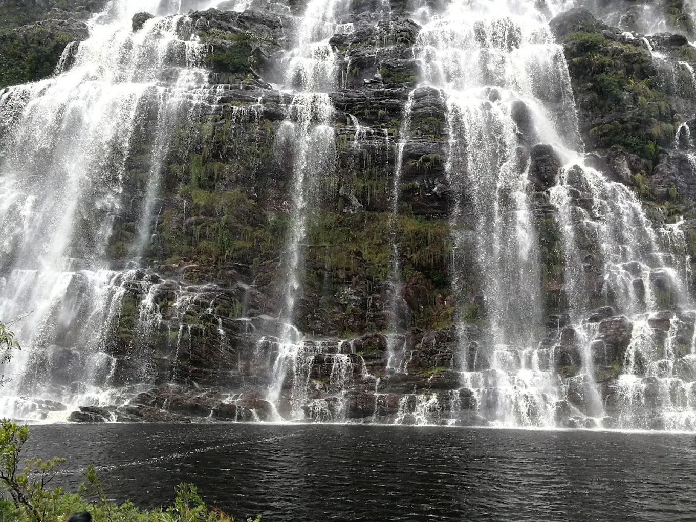 Queda completa da Cachoeira do Lajeado sobre paredão rochoso, com o poço na base, em Lapinha da Serra