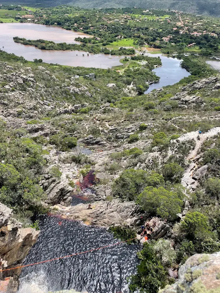 Vista aérea da trilha e do poço da Cachoeira do Rapel, com o vilarejo de Lapinha da Serra ao fundo