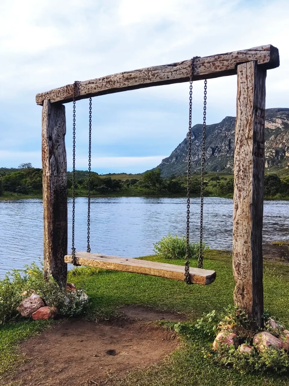 Margem gramada da Prainha, à beira da represa de Lapinha da Serra, com a serra ao fundo