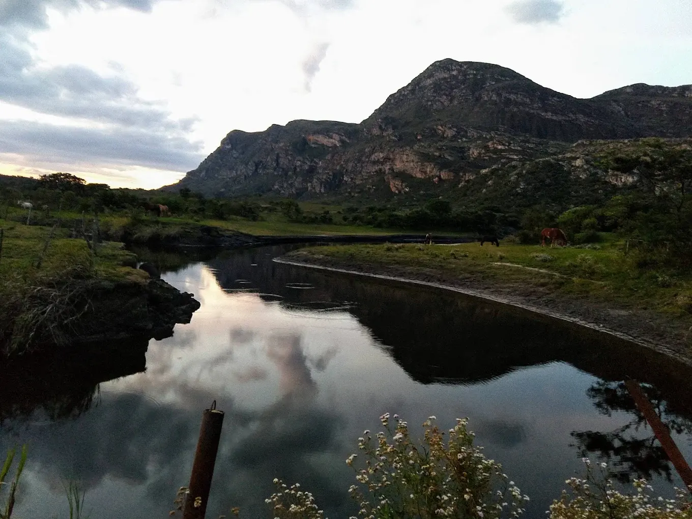 Primeira vista da represa de Lapinha da Serra, com cavalos pastando na margem e a serra ao fundo