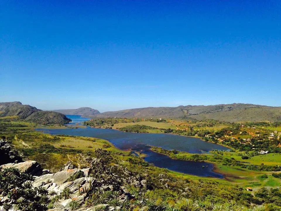 Vista aérea do vilarejo de Lapinha da Serra com a represa e as montanhas da Serra do Espinhaço ao fundo